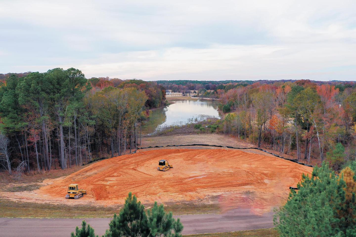 CAT excavator clearing trees and roots on a land clearing job site in Arkansas