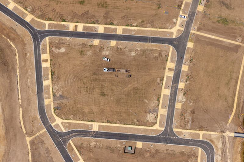 Excavator and dozer grading red clay during site development